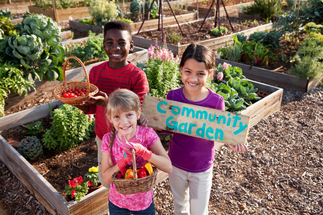 Children holding community garden sign